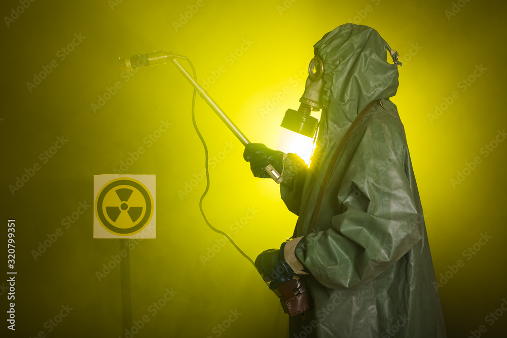 Obraz premium Radiation and danger concept - Man in the gas mask and chemical suit. The worker doing measure radioactivity