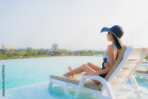 Portrait beautiful young asian woman happy smile relax around outdoor swimming pool in hotel resort © siraphol