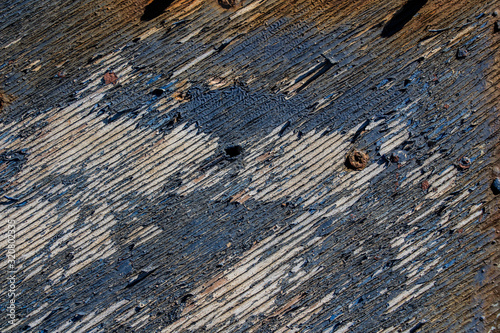 texture of old wooden painted in blue, blue peeling paint wooden desk background, peeled paint over wood boards from a boat hull