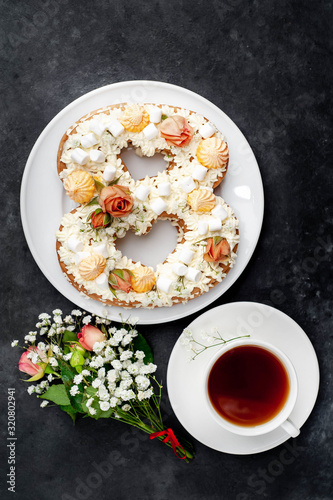 tea and cake in the form of 8 is decorated with flowers, cream cheese, marshmallows, Bizet on a stone background. romantic delicious breakfast on International Women's Day March 8