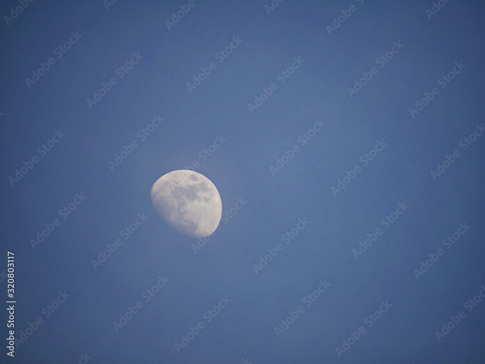 View of a gibbous moon in blue skies background