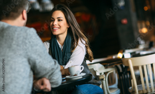 Young couple at the bar having a coffee and flirting