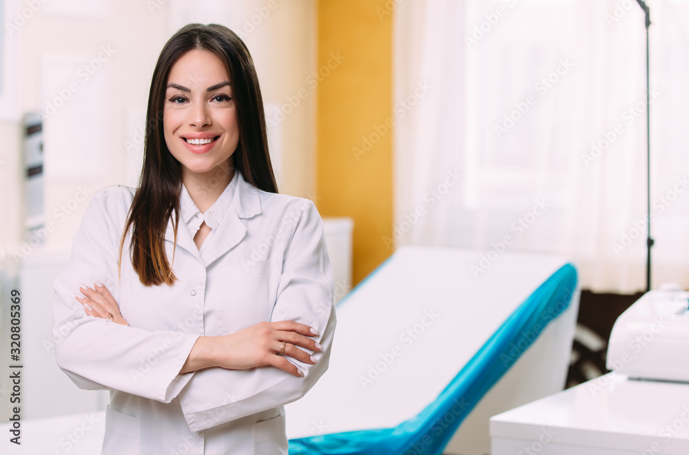 Portrait of smiling female doctor wearing white coat in hospital office Portrait of smiling female doctor wearing white coat in hospital office