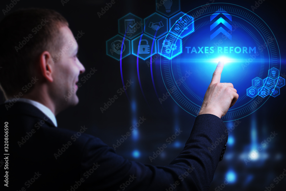 Business, Technology, Internet and network concept. Young businessman working on a virtual screen of the future and sees the inscription: taxes reform Business, Technology, Internet and network concept. Young businessman working on a virtual screen of the future and sees the inscription: taxes reform