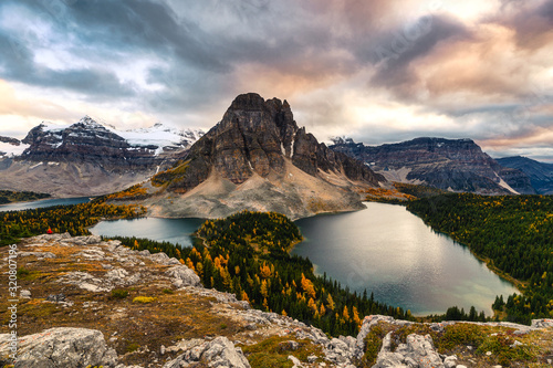 Mount Assiniboine with lake on Nublet peak in autumn forest on sunset at provincial park photo