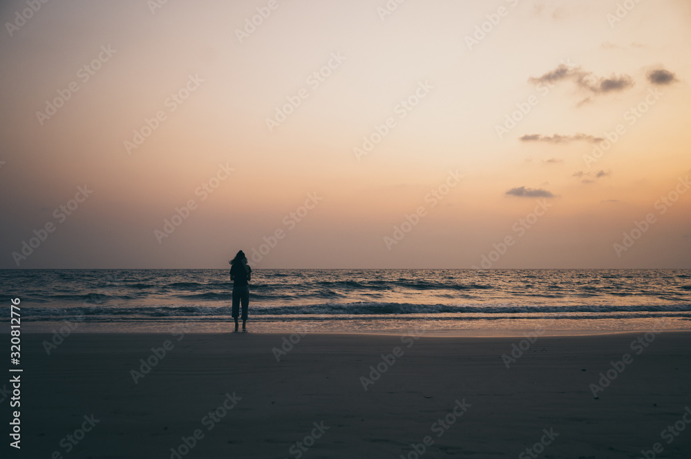 silhouette of the lonely man and the sea during sunset