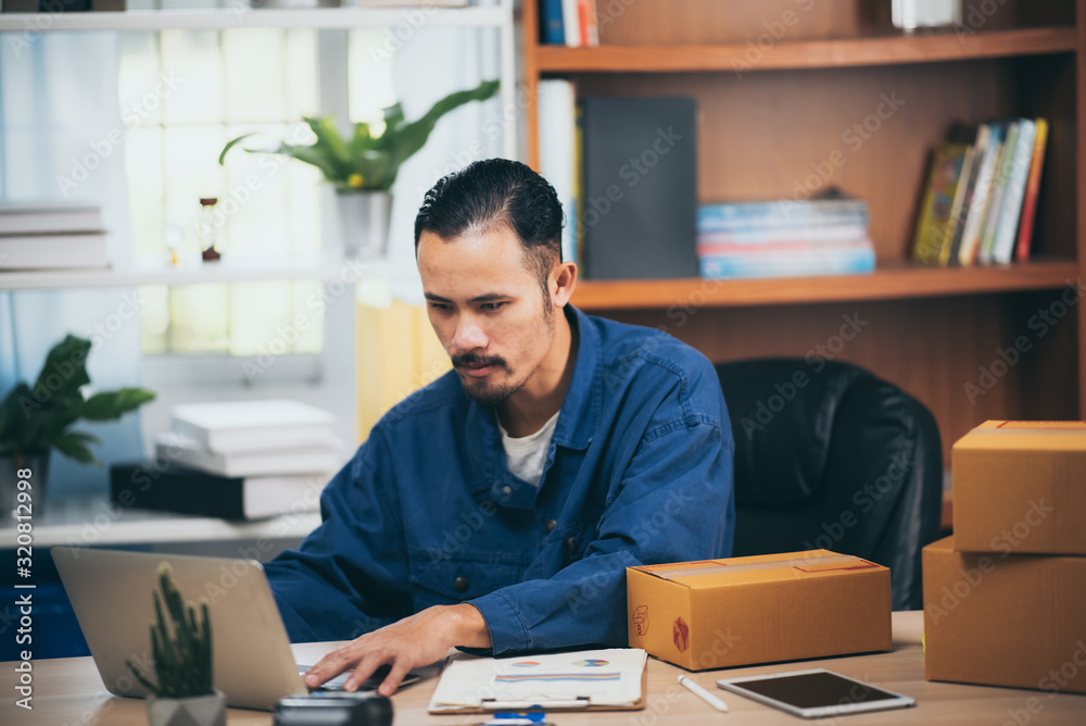 Small business owner packing in the box at workplace. Cropped shot of man preparing a parcel for delivery at online selling business office. Small business owner packing in the box at workplace. Cropped shot of man preparing a parcel for delivery at online selling business office.