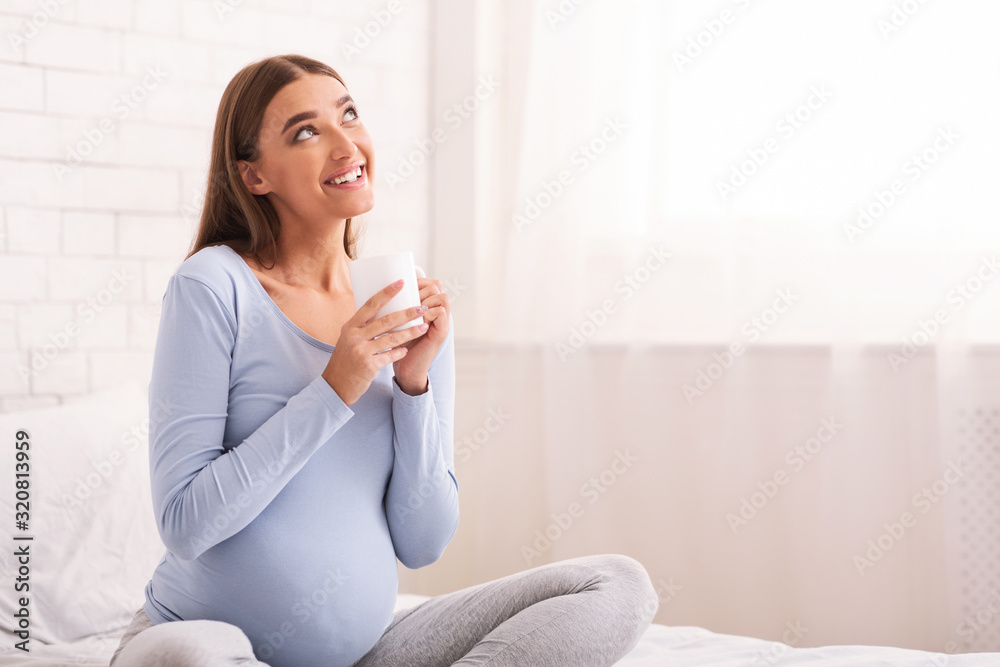 Excited Mother-To-Be Having Coffee Sitting In Bed At Home Excited Mother-To-Be Having Coffee Sitting In Bed At Home