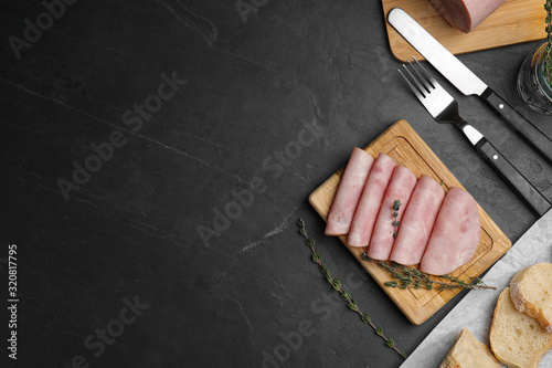 Fotografija Tasty ham served on black table, flat lay. Space for text