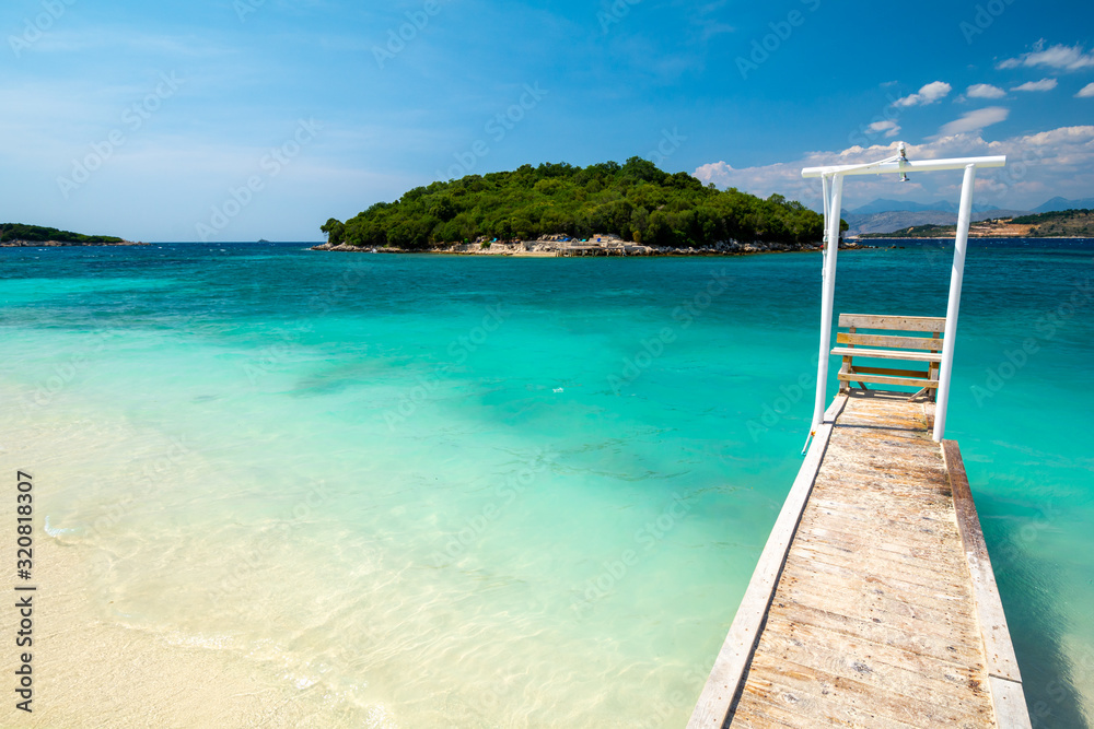 Paradise beach with wooden pier in Ksamil in Albania Paradise beach with wooden pier in Ksamil in Albania