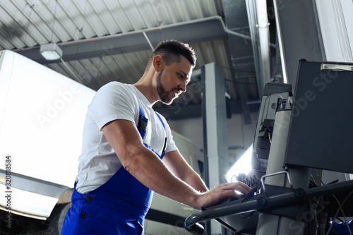 Mechanic doing car diagnostic at automobile repair shop