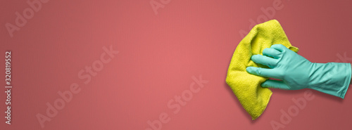 woman hand on latex glove holding a color rag isolated and wash a color surface