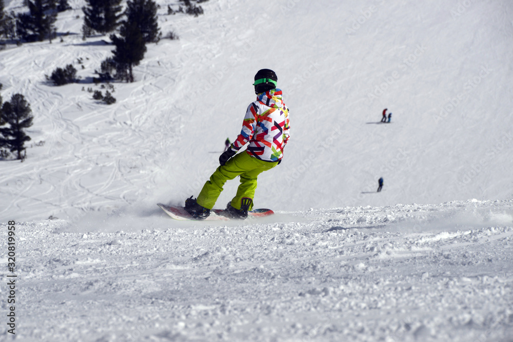 A snowboarder an a ski driver on the piste in Bansko, Bulgaria. A snowboarder an a ski driver on the piste in Bansko, Bulgaria.