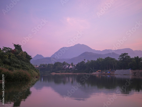 River curve with a mountain view in the evening time, a shore is under construction