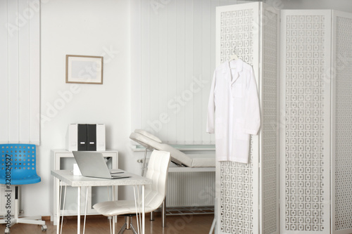 Εκτύπωση καμβά Doctor's office interior with desk, examination couch and folding screen