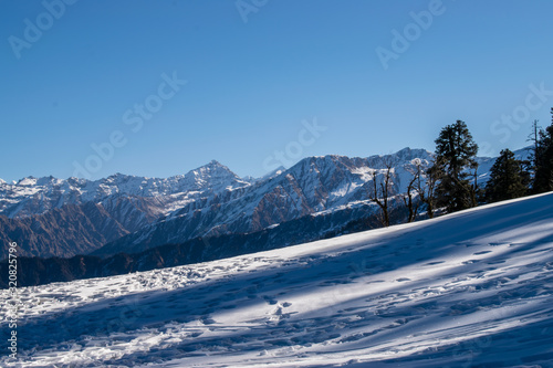 Amazing view of snow clad mountain landscape during Kedarkantha winter trek in Uttarkashi, Uttarakhand (India). Trek in December on Christmas and New Year