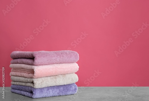 Stack of color towels on light grey stone table. Space for text