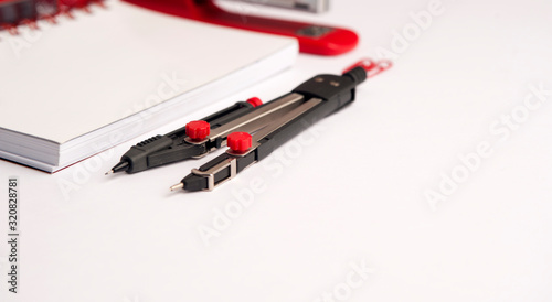 set of work table with compass crafts, white notebook, red stapler, on white background