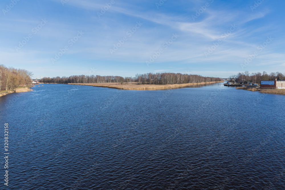 City, Riga, Latvia. River with reeds and glare. Travel photo.