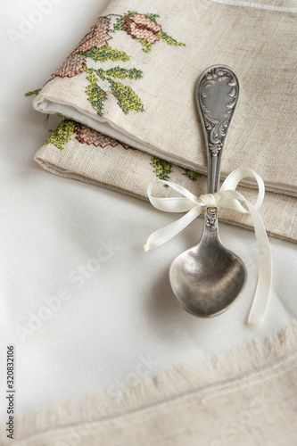 Vintage russian silverspoon with silk ribbon on linen napkin. Old fashion heroloom silverware photo