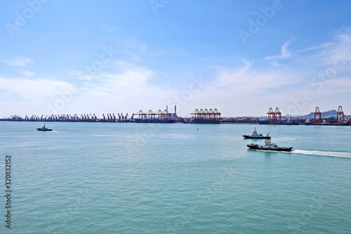 Panoramic views of piers, sea vessels, tugboats and the city of Rizhao, China. photo