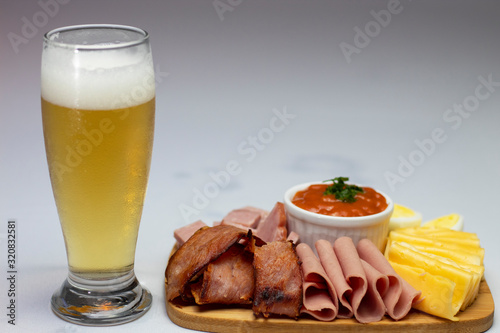 Appetizer with cheese, ham, bacon, salami, cachaça and sauce