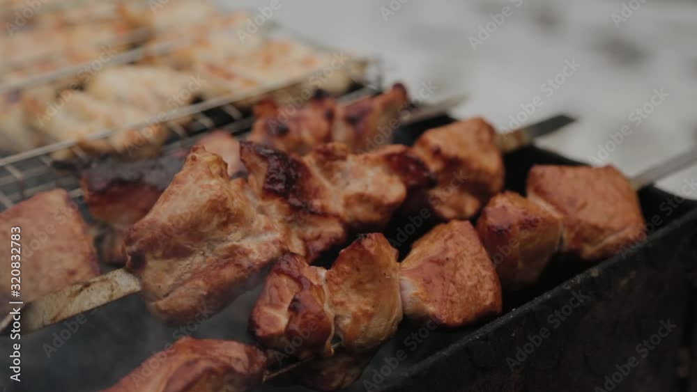 The process of cooking barbecue on fire in winter weather on a background of snow. The process of cooking barbecue on fire in winter weather on a background of snow.