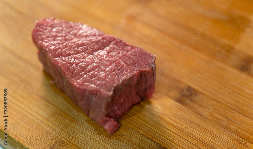 A piece of meat prepared for cutting. Lies on a wooden board. A piece of meat prepared for cutting. Lies on a wooden board.