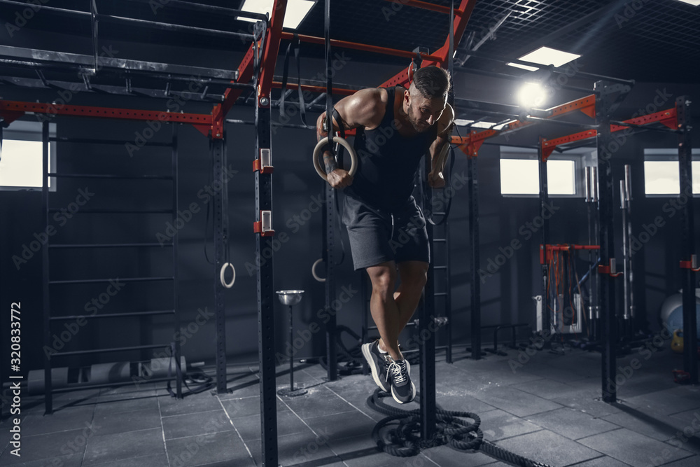 Flying hard. Young muscular caucasian athlete practicing pull-ups in ...