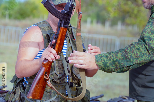 A soldier holds an old Russian machine gun from the second world war photo