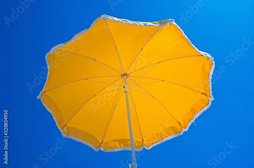 Holiday by the swimming pool with detail of yellow umbrella