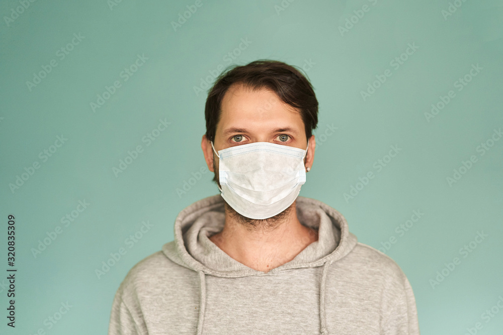 Man in a medical mask on a green background. Coronavirus. Prevention of viral diseases Man in a medical mask on a green background. Coronavirus. Prevention of viral diseases