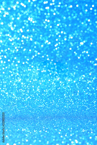 Vertical blue glitter background with blur and bokeh