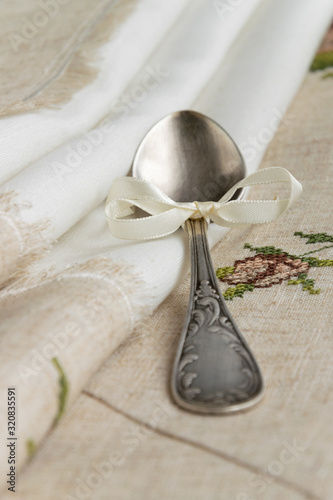 Fotografie Vintage russian silverspoon with silk ribbon on linen napkin