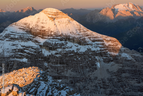 Dawn from the top of Tofana di Mezzo (3244 m) towards Tofana di Rozes after a slight summer snowfall, in the background the Marmolada glacier, Cortina d'Ampezzo, dolomites, Italy photo