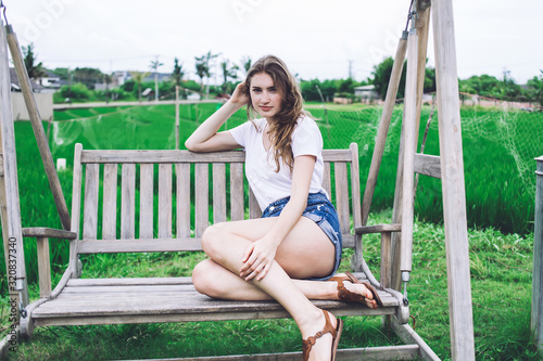 Young woman sitting on bench swing
