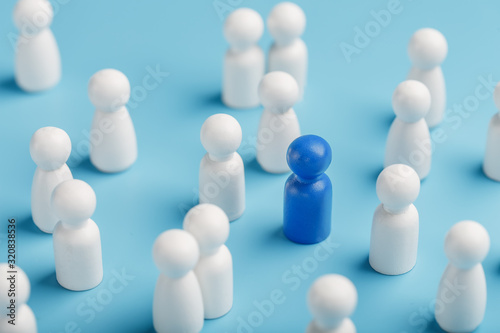 The leader of the blue color stands among the crowd  a group of white employees. The concept of leadership. Many employees are drawn to their boss. Personnel selection.