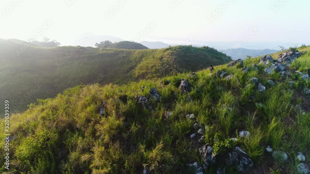 Aerial Orbit Shot Of Woman Hiker Passing The Big Rocks On Top Of A Mountain Aerial Orbit Shot Of Woman Hiker Passing The Big Rocks On Top Of A Mountain
