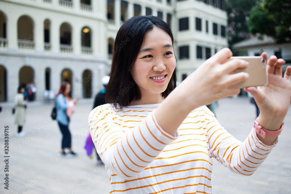 Asian tourist taking selfie on square