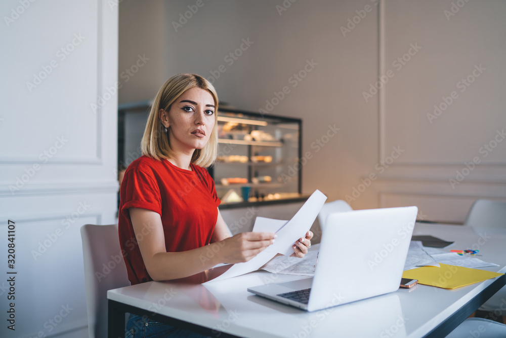 Gorgeous lady reviewing paperwork in cafe