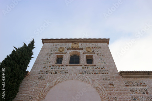 view from below to the Church of Santa Maria de la Alhambra with winter sky on the background