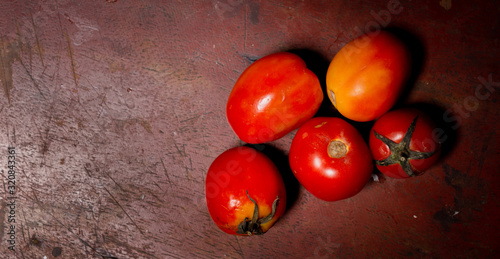 Fresh tomatoes in a plate on a dark background. Harvesting tomatoes. Top view