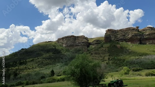 Moluti sandstone cliffs at the border of Lesotho in South Africa at the Camelroc travel guest farm, stunning cloud time lapse, most amazing mountains and green scenery landscapes photo