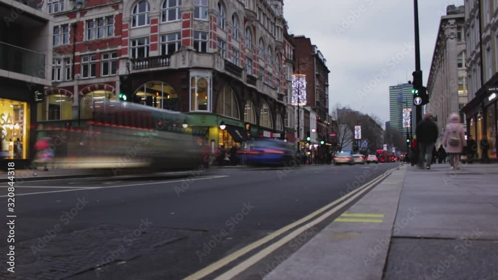 Timelapse, London red bus passing by the camera from left to right. People walking on sidewalk in winter. Cars crossing the street in the city center, London, United Kingdom Timelapse, London red bus passing by the camera from left to right. People walking on sidewalk in winter. Cars crossing the street in the city center, London, United Kingdom