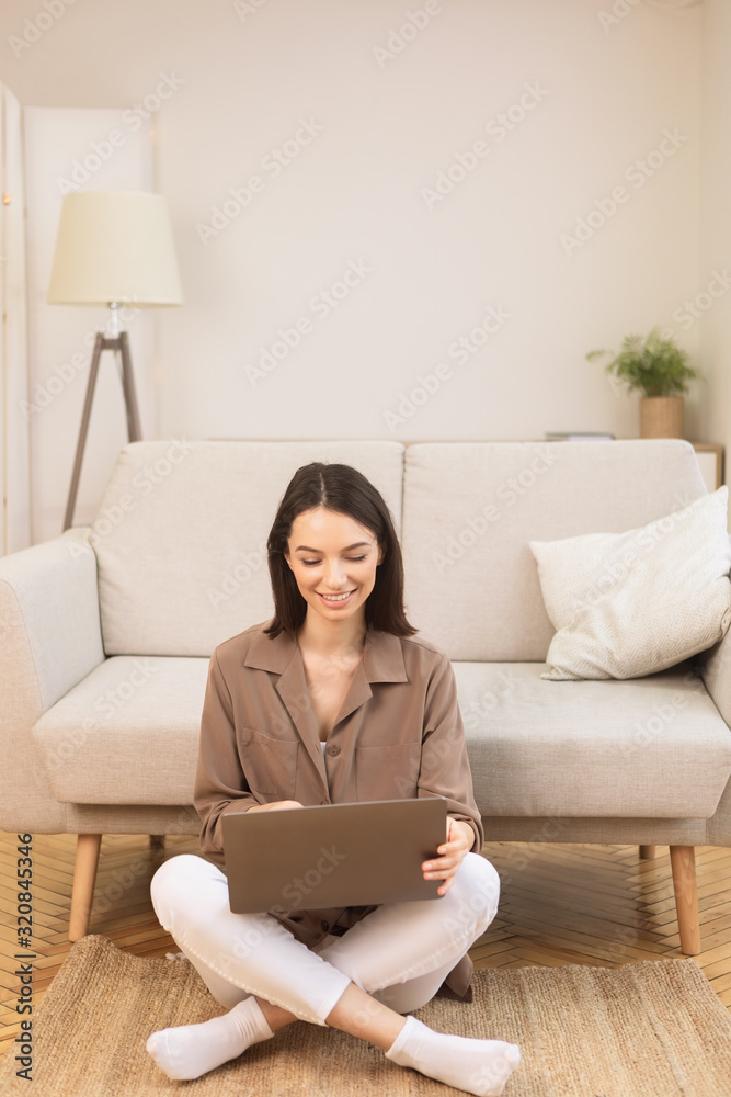 Girl working on laptop sitting on the floor Girl working on laptop sitting on the floor