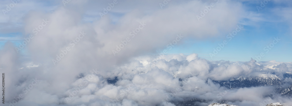 Beautiful View of the Cloudscape over the Canadian Mountain Landscape during a sunny and cloudy winter day. Taken in Whistler, BC, Canada. Good for Background, Backdrop