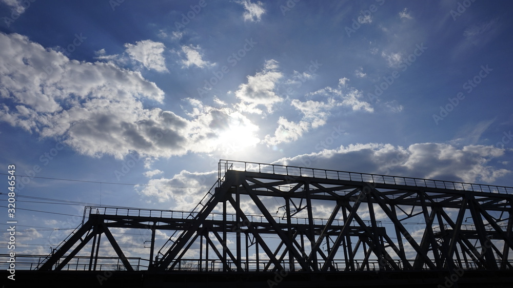 metal construction of a railway bridge against a blue sky