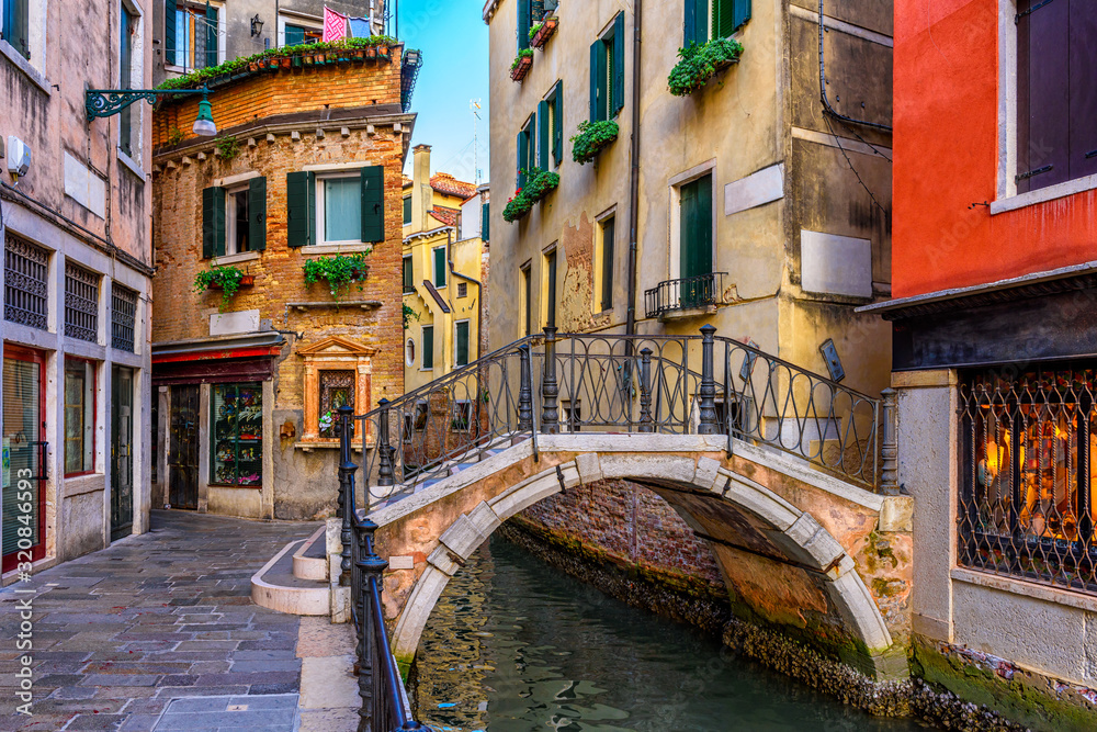 Narrow canal with boat and bridge in Venice, Italy. Architecture and landmark of Venice. Cozy cityscape of Venice. Narrow canal with boat and bridge in Venice, Italy. Architecture and landmark of Venice. Cozy cityscape of Venice.