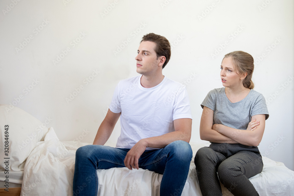 Caucasian man and woman have argument sit on bed in bedroom,Conflict violent and annoyed couple with unhappy relationship. Caucasian man and woman have argument sit on bed in bedroom,Conflict violent and annoyed couple with unhappy relationship.