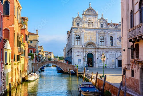 Fotografia Narrow canal with bridge and facade of hospital Giovanni and Paolo in Venice, Italy